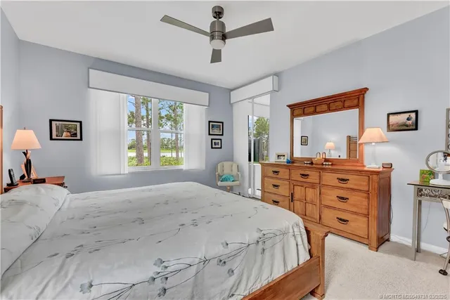 a bedroom with a bed and a dresser next to a window