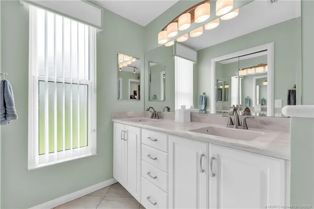 a bathroom with a double vanity sink and a mirror
