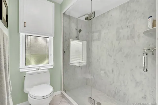 a bathroom with a toilet and a shower