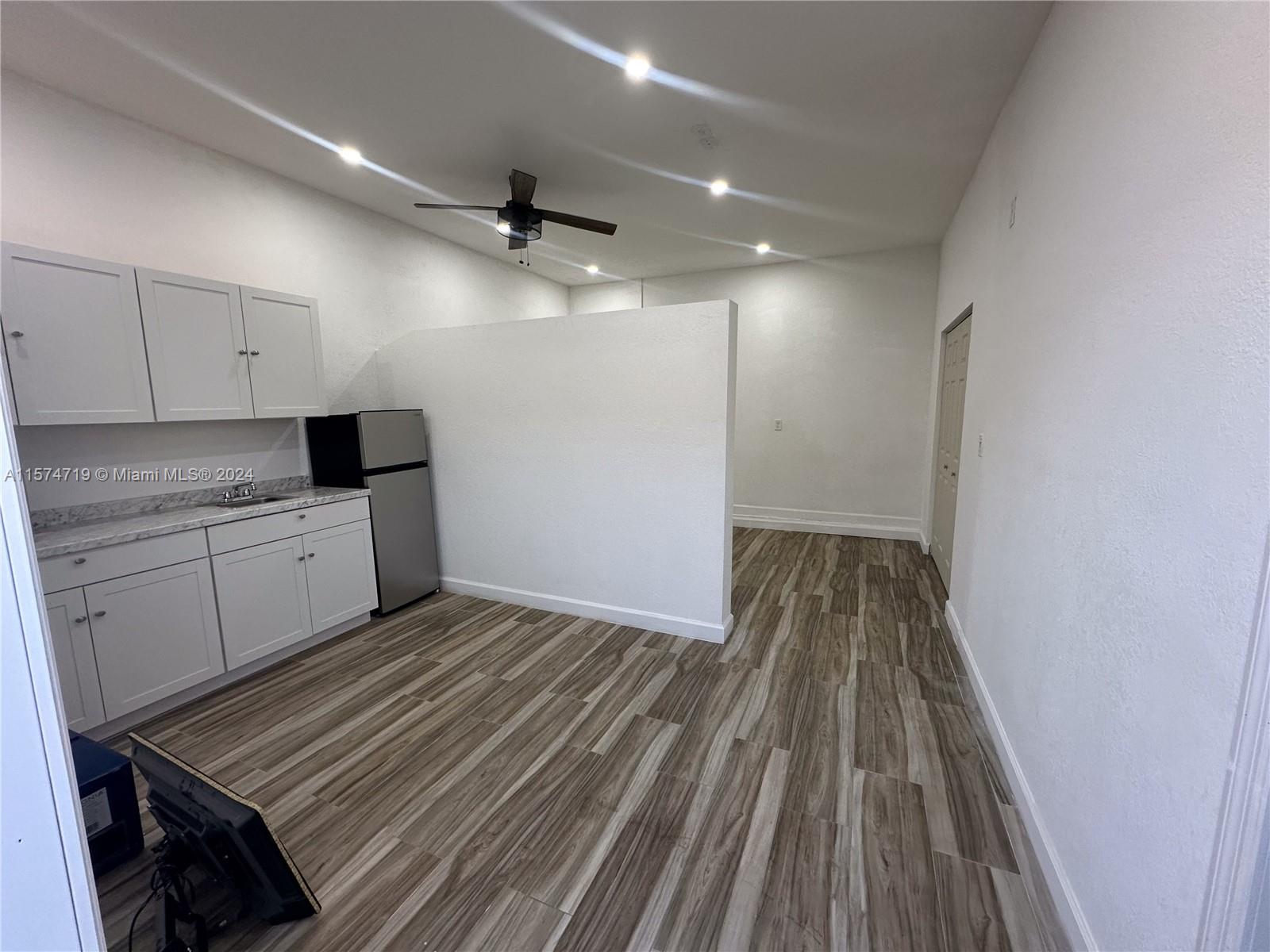 27176 Southwest 132 Ct Road, Unit 2 Homestead, FL 33032 - Photo 3 of 10 a kitchen with cabinets and wooden floor