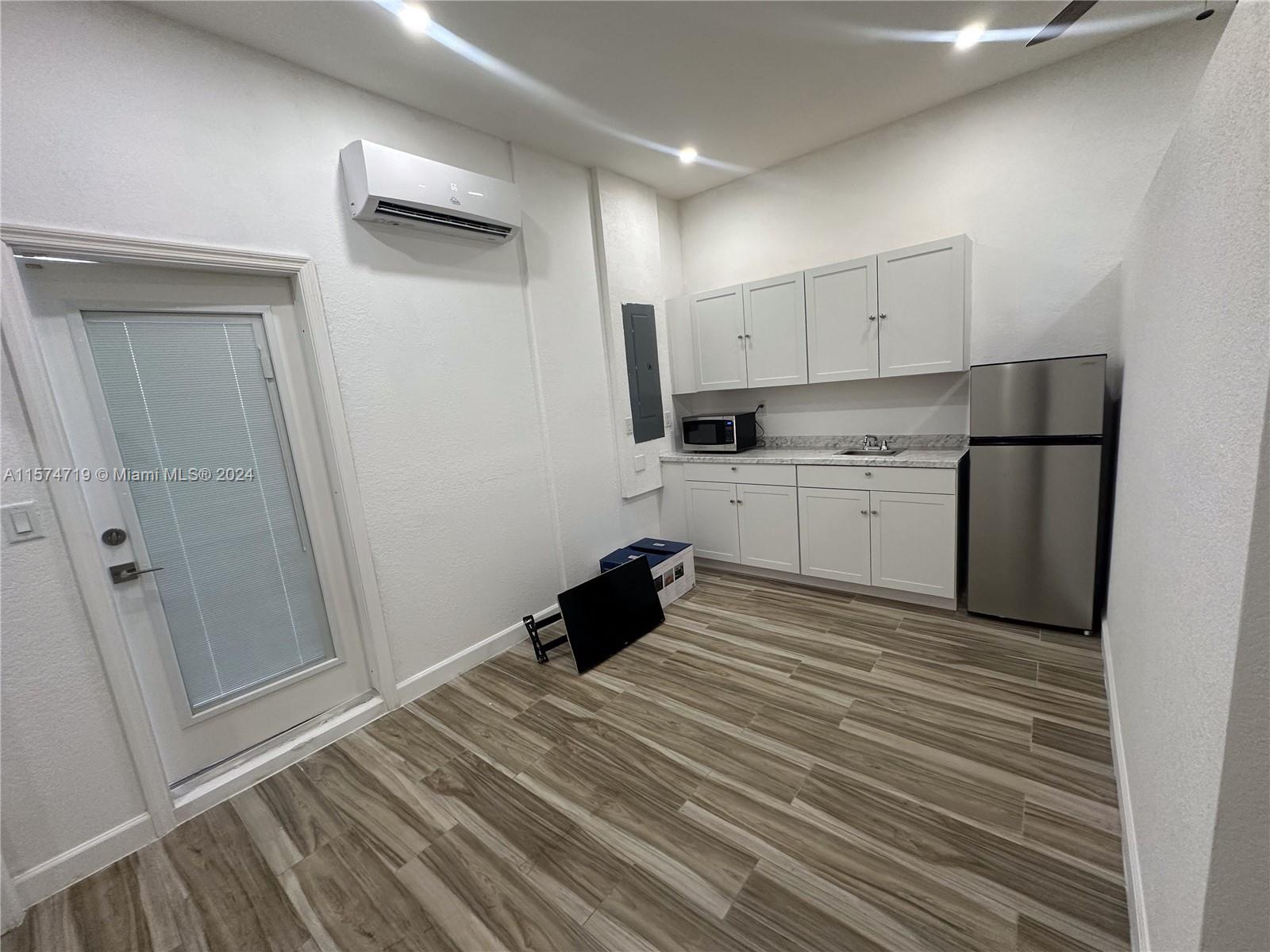 27176 Southwest 132 Ct Road, Unit 2 Homestead, FL 33032 - Photo 5 of 10 a kitchen with a refrigerator and white cabinets
