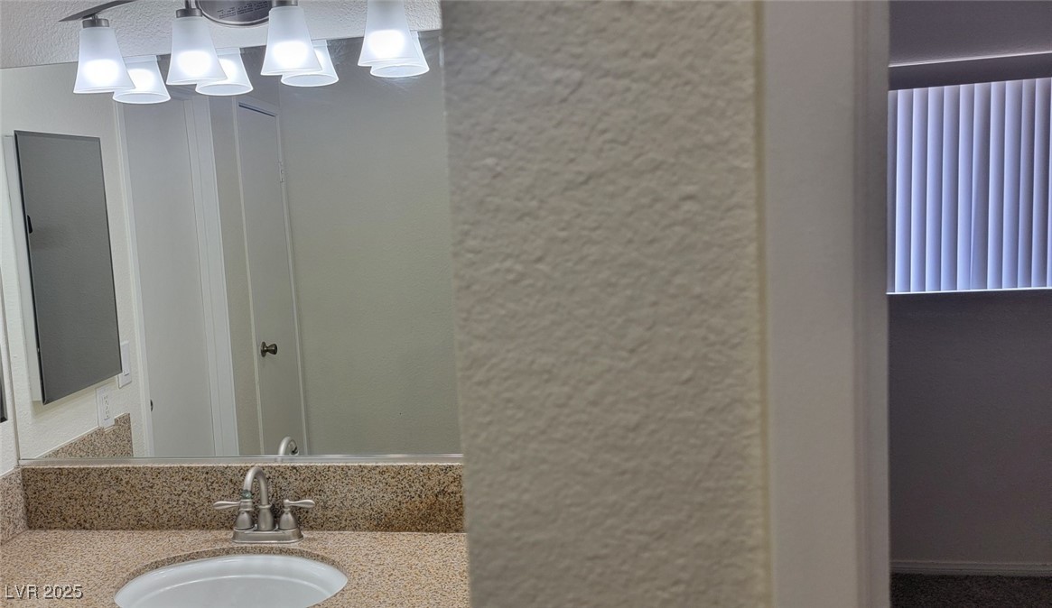 5196 Golden Lane, Unit C Las Vegas, NV 89119 - Photo 19 of 29 Bathroom featuring vanity and a chandelier