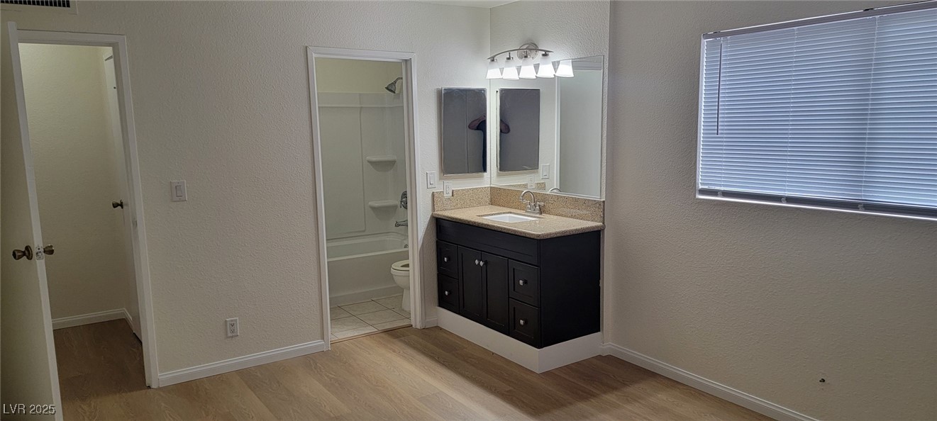 5196 Golden Lane, Unit C Las Vegas, NV 89119 - Photo 3 of 29 Full bath featuring wood finished floors, vanity, and shower / bathtub combination