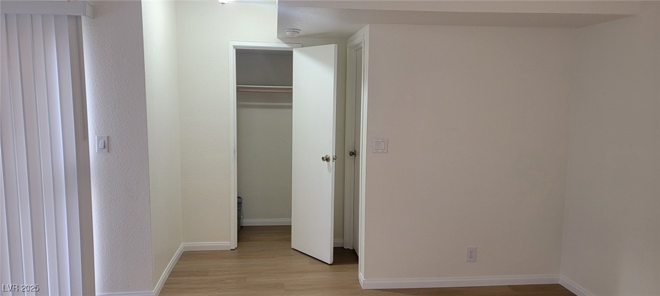 5196 Golden Lane, Unit C Las Vegas, NV 89119 - Photo 7 of 29 Unfurnished bedroom featuring light wood-style flooring and a closet