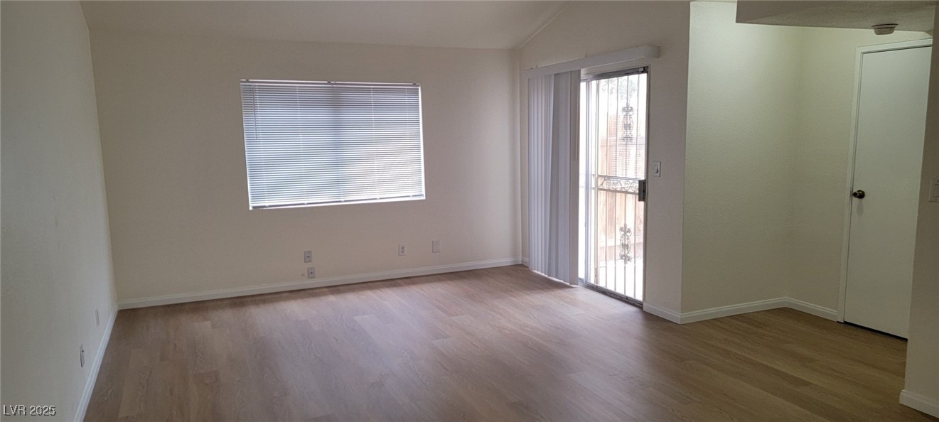 5196 Golden Lane, Unit C Las Vegas, NV 89119 - Photo 9 of 29 Unfurnished room featuring wood finished floors and vaulted ceiling