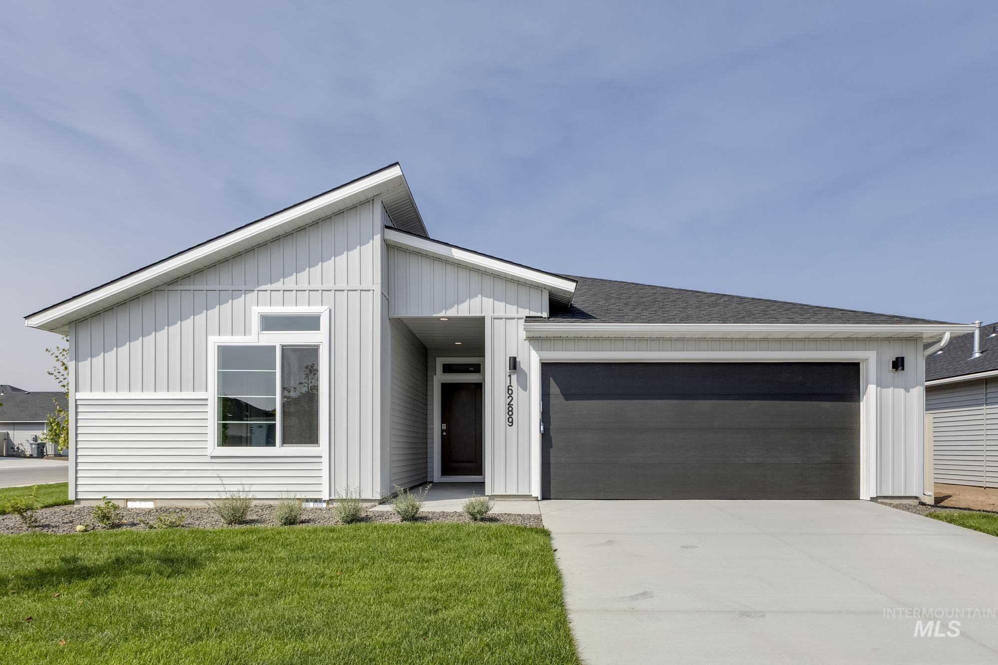 16289 Fill Avenue Caldwell, ID 83607 - Photo 1 of 1 View of front of house with board and batten siding, a garage, concrete driveway, and a front yard