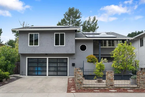 a front view of a house with glass windows and entertaining space
