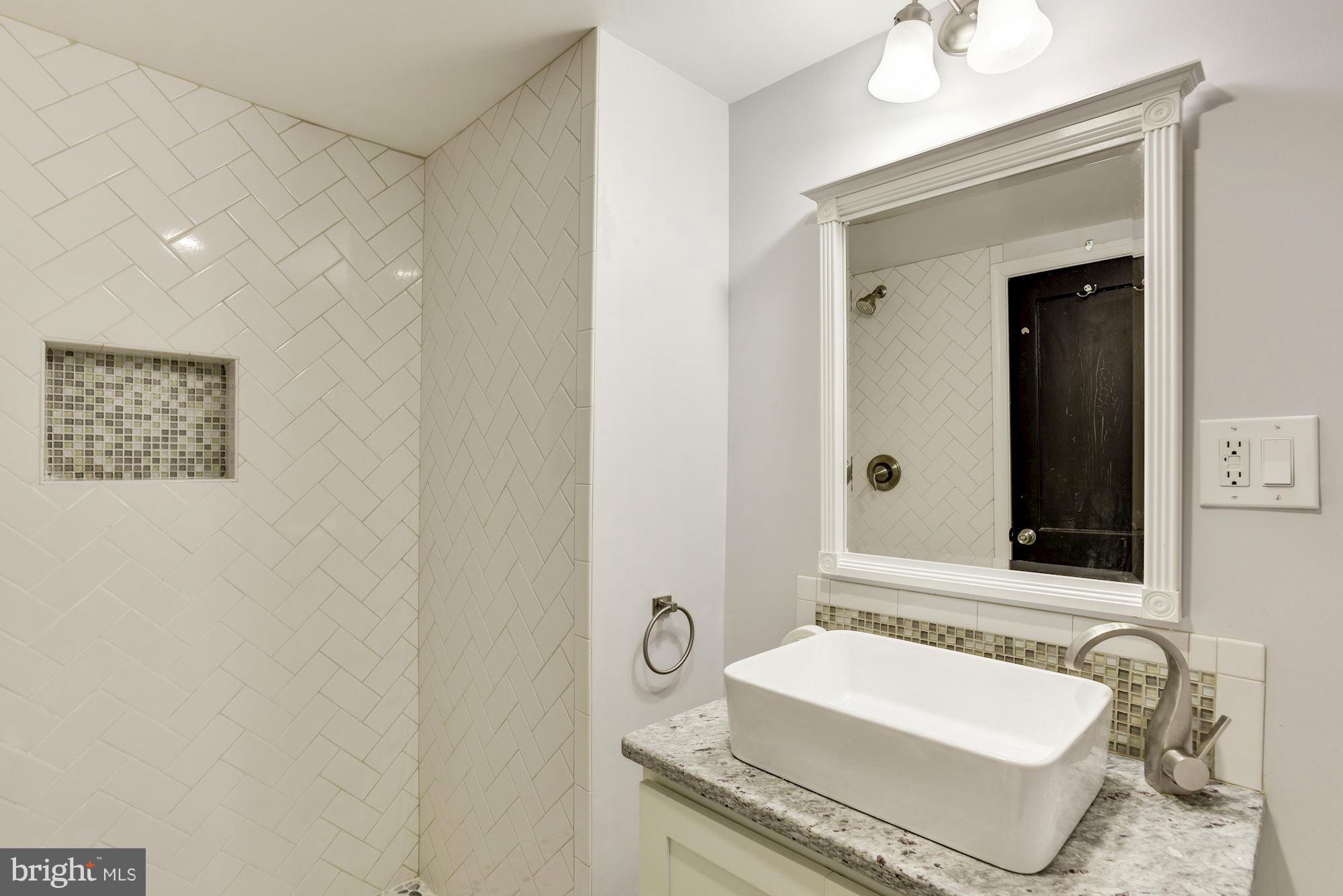 1966 Edgewood Road Baltimore, MD 21286 - Photo 23 of 26 a bathroom with a granite countertop sink and a mirror