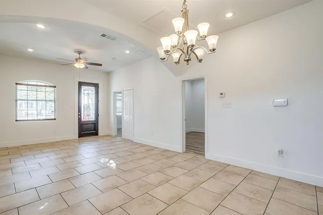 a view of a livingroom with a chandelier fan and windows