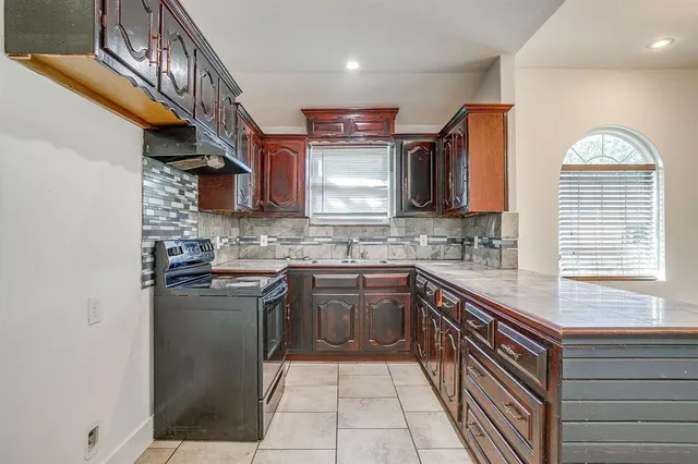 a kitchen with stainless steel appliances granite countertop a sink a stove and cabinets