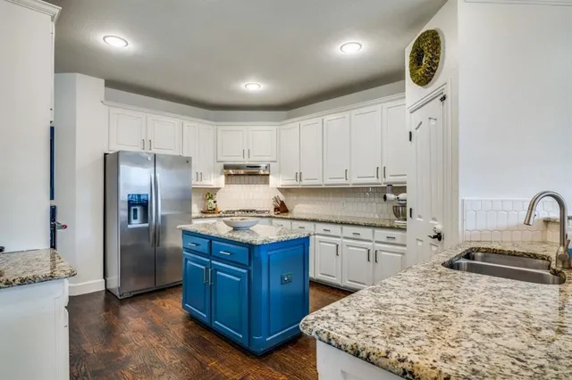 a kitchen with stainless steel appliances granite countertop a sink stove and refrigerator
