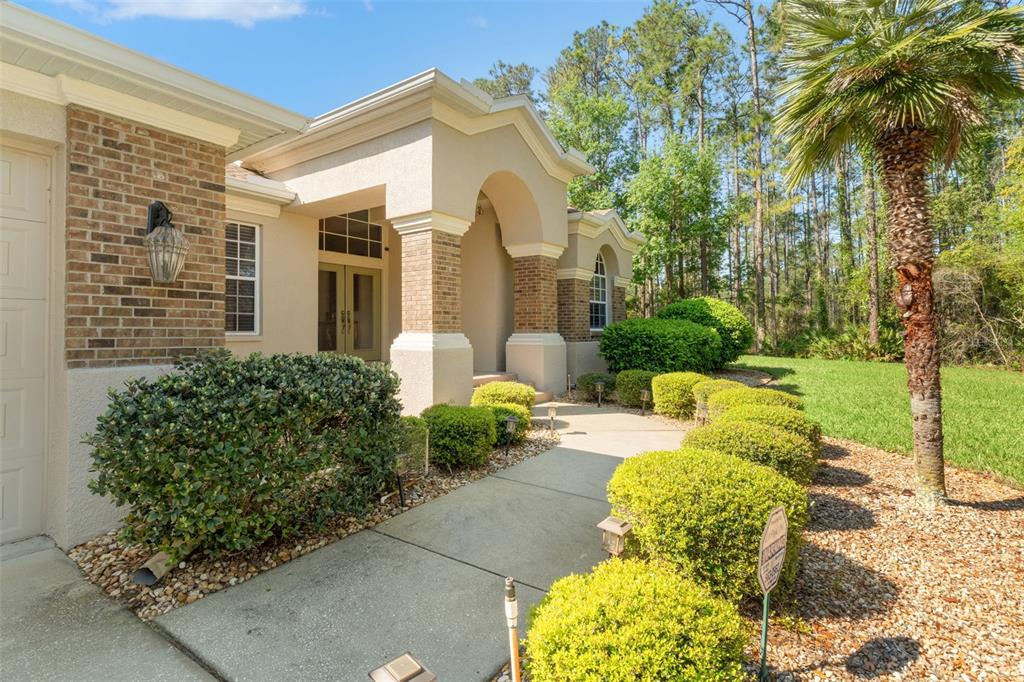 10260 Waters Edge Court Weeki Wachee, FL 34613 - Photo 11 of 58 a view of a white house with a yard and potted plants