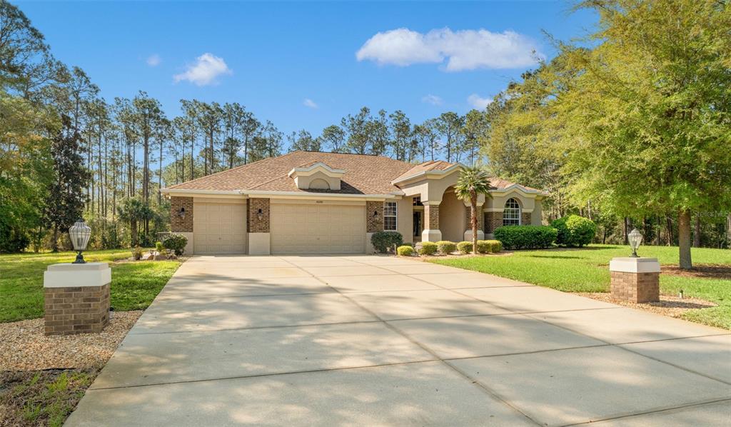 10260 Waters Edge Court Weeki Wachee, FL 34613 - Photo 9 of 58 a front view of a house with a yard and trees