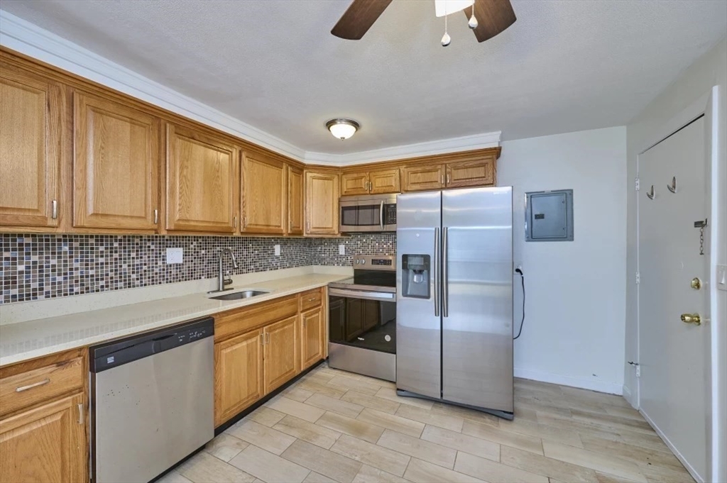 87 Cedar Street, Unit 10 Malden, MA 02148 - Photo 2 of 16 a kitchen with a refrigerator sink and cabinets