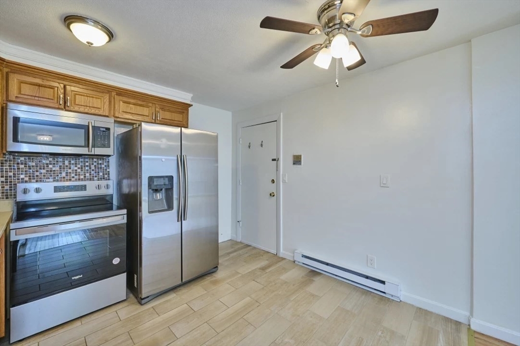 87 Cedar Street, Unit 10 Malden, MA 02148 - Photo 5 of 16 a view of a kitchen with a refrigerator and cabinets