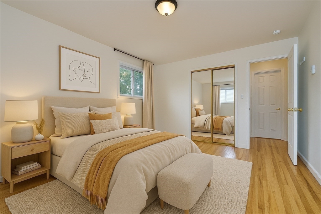 87 Cedar Street, Unit 10 Malden, MA 02148 - Photo 8 of 16 a bedroom with a bed and wooden floor