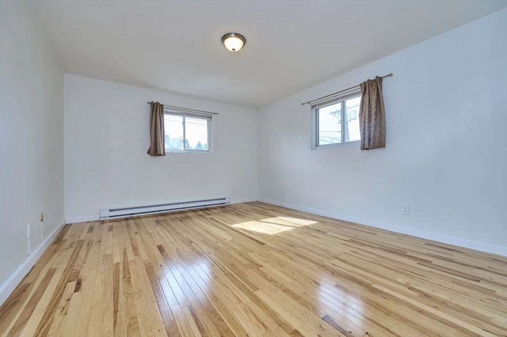 87 Cedar Street, Unit 10 Malden, MA 02148 - Photo 10 of 16 a view of empty room with wooden floor and fan