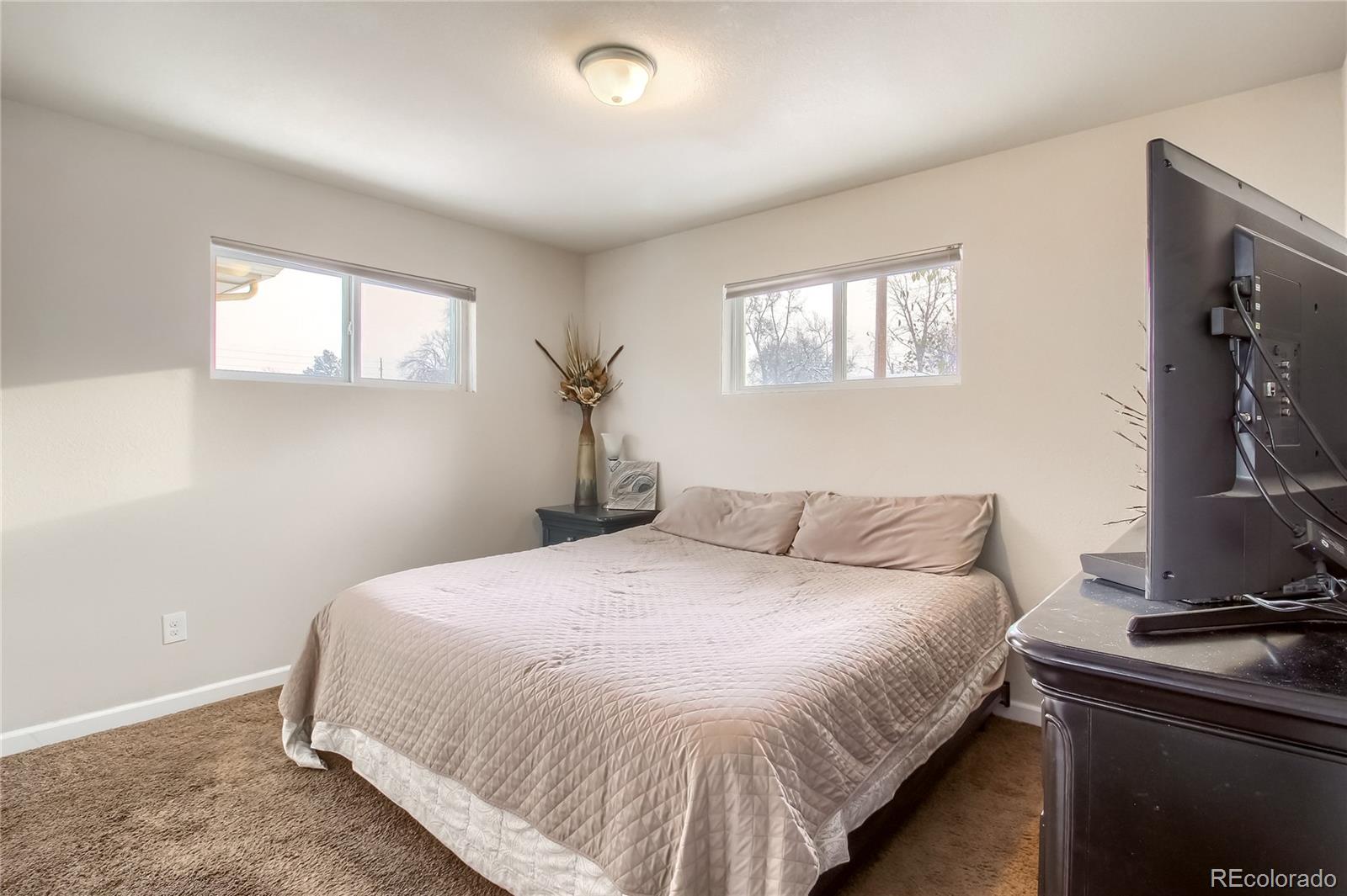 7545 Turner Drive Denver, CO 80221 - Photo 14 of 38 a bedroom with a bed and a flat screen tv