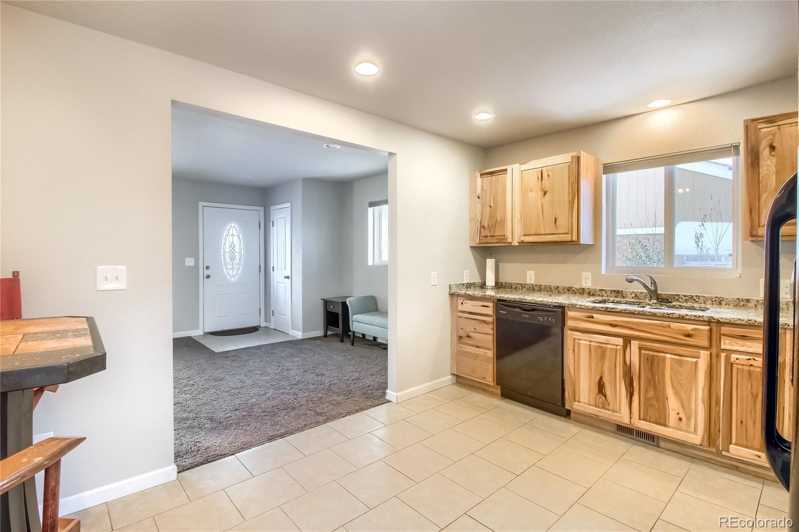 7545 Turner Drive Denver, CO 80221 - Photo 10 of 38 a large kitchen with granite countertop a sink and white cabinets