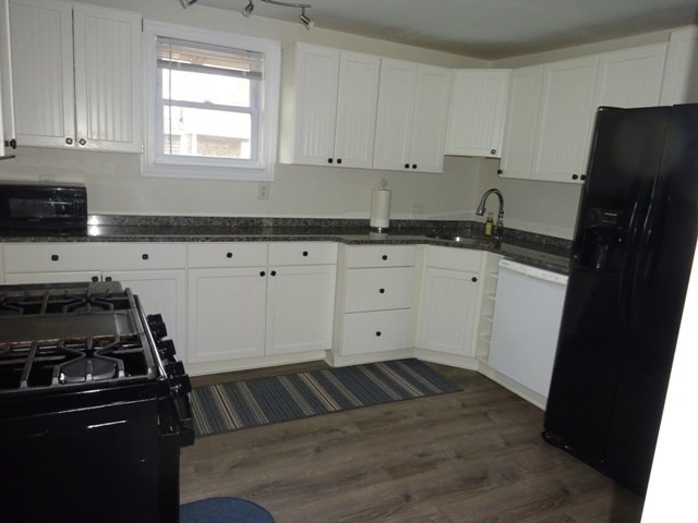 83 Shore Avenue, Unit 83 Wareham, MA 02571 - Photo 12 of 32 a kitchen with granite countertop a refrigerator stove and white cabinets