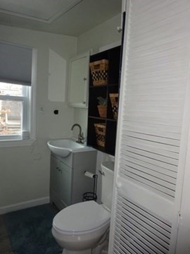 83 Shore Avenue, Unit 83 Wareham, MA 02571 - Photo 21 of 32 a white toilet sitting next to a bathroom sink and vanity