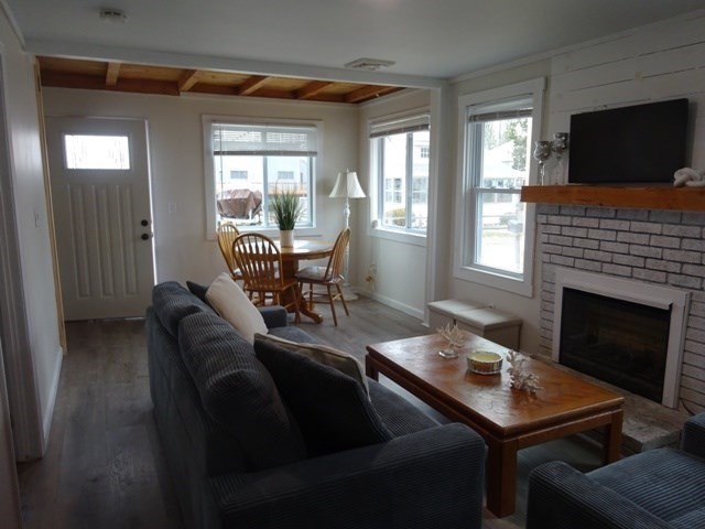 83 Shore Avenue, Unit 83 Wareham, MA 02571 - Photo 6 of 32 a living room with furniture a flat screen tv and a fireplace