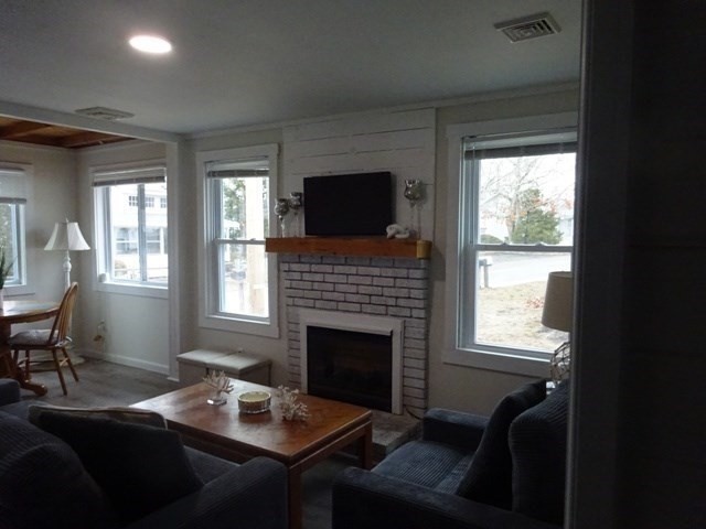 83 Shore Avenue, Unit 83 Wareham, MA 02571 - Photo 7 of 32 a living room with furniture a flat screen tv and a fireplace