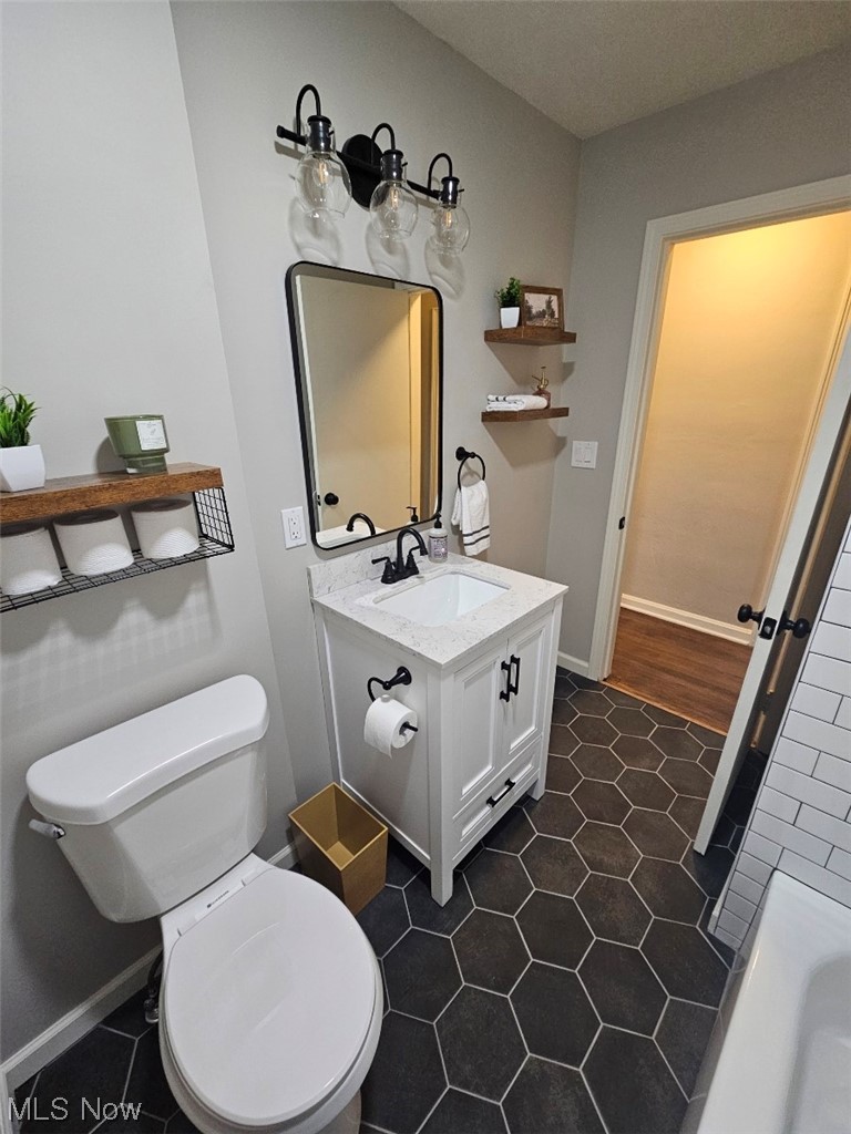 3439 Surrey Road Southeast Warren, OH 44484 - Photo 6 of 32 Main bathroom featuring all new tile floors, vanity, lights, fixtures and toilet