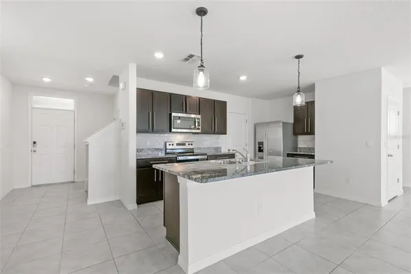 a kitchen with a sink a stove a refrigerator and a oven