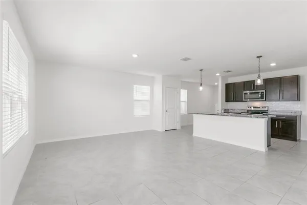 a view of kitchen with kitchen island and stainless steel appliances