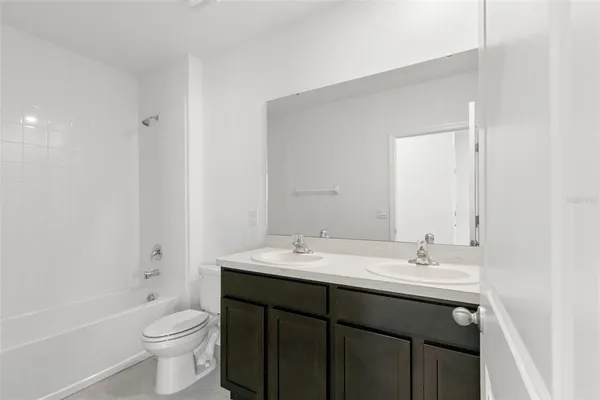 a bathroom with a sink a toilet a large mirror and shower