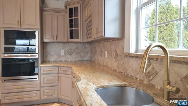 a kitchen with granite countertop a sink and a stove