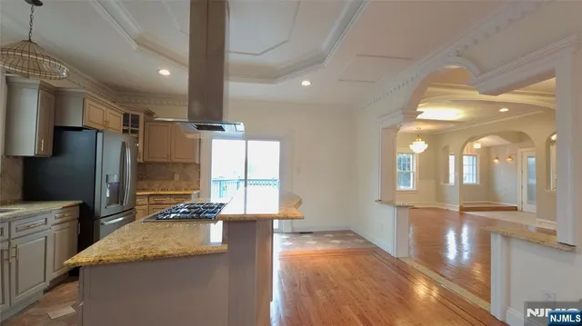 a kitchen with stainless steel appliances granite countertop a refrigerator a sink and a stove