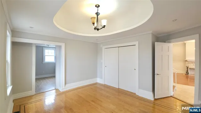 a view of a livingroom with a chandelier fan and windows