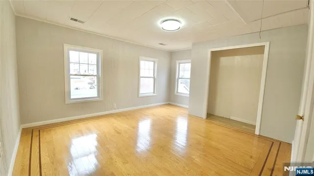 a view of an empty room with window and a bathroom