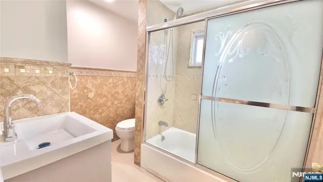 a bathroom with a tub a sink and a mirror