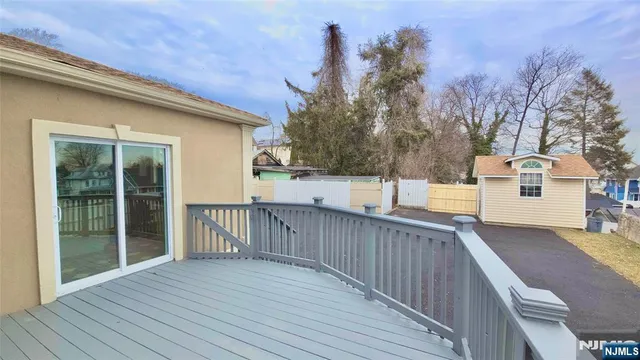 a view of a house with wooden deck and a backyard