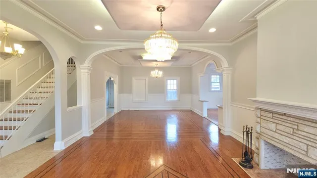 a view of a hallway with wooden floor and chandelier