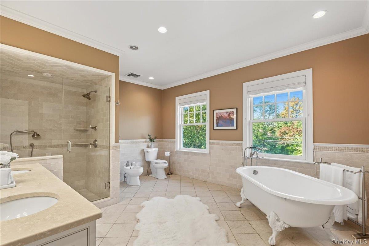 96 Brookby Road Scarsdale, NY 10583 - Photo 20 of 45 Primary bathroom featuring a glass enclosed shower, double vanity and beautiful soaking tub