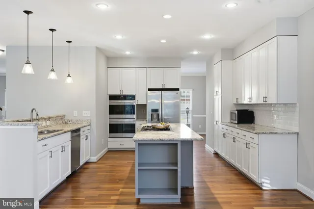 a kitchen with kitchen island a sink stainless steel appliances and cabinets