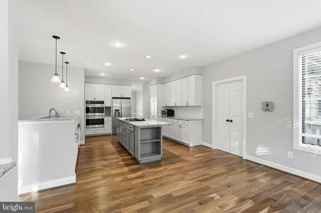 a large kitchen with a lot of counter space and stainless steel appliances