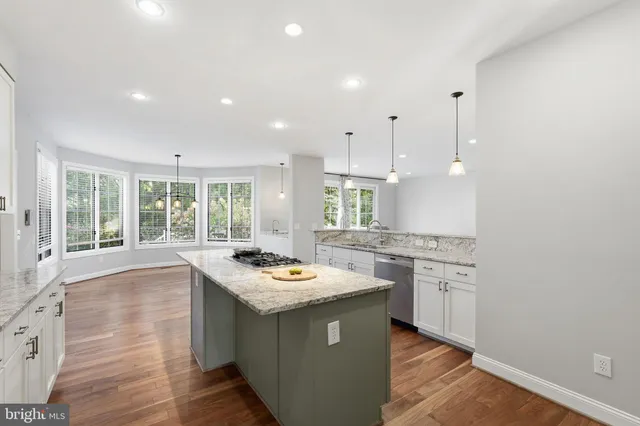 a kitchen with a stove a sink a counter space and a window