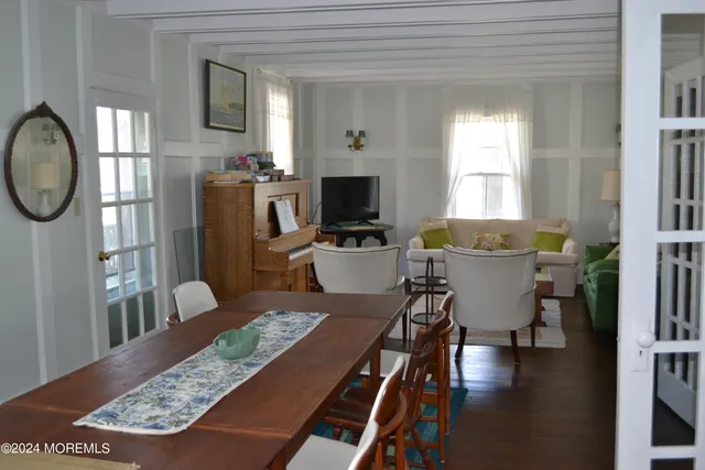 a view of a dining room with furniture a rug and wooden floor