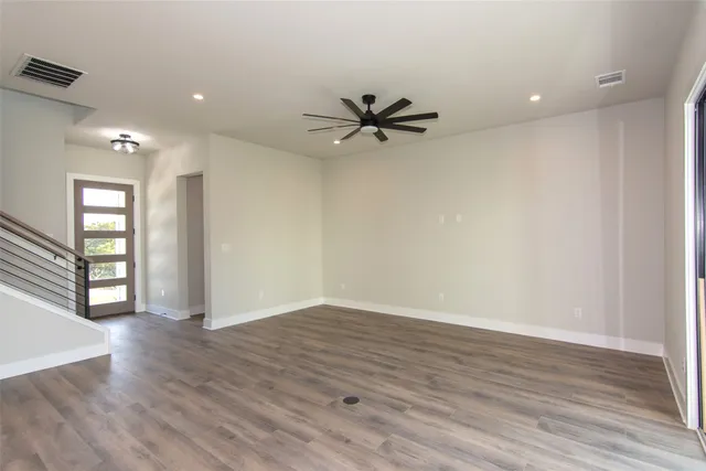 a view of kitchen with stainless steel appliances granite countertop a stove top oven a sink and a microwave with wooden floors