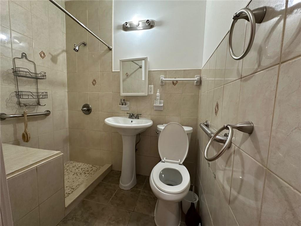 143-20 182nd Place Queens, NY 11413 - Photo 11 of 17 a bathroom with a sink a toilet and shower