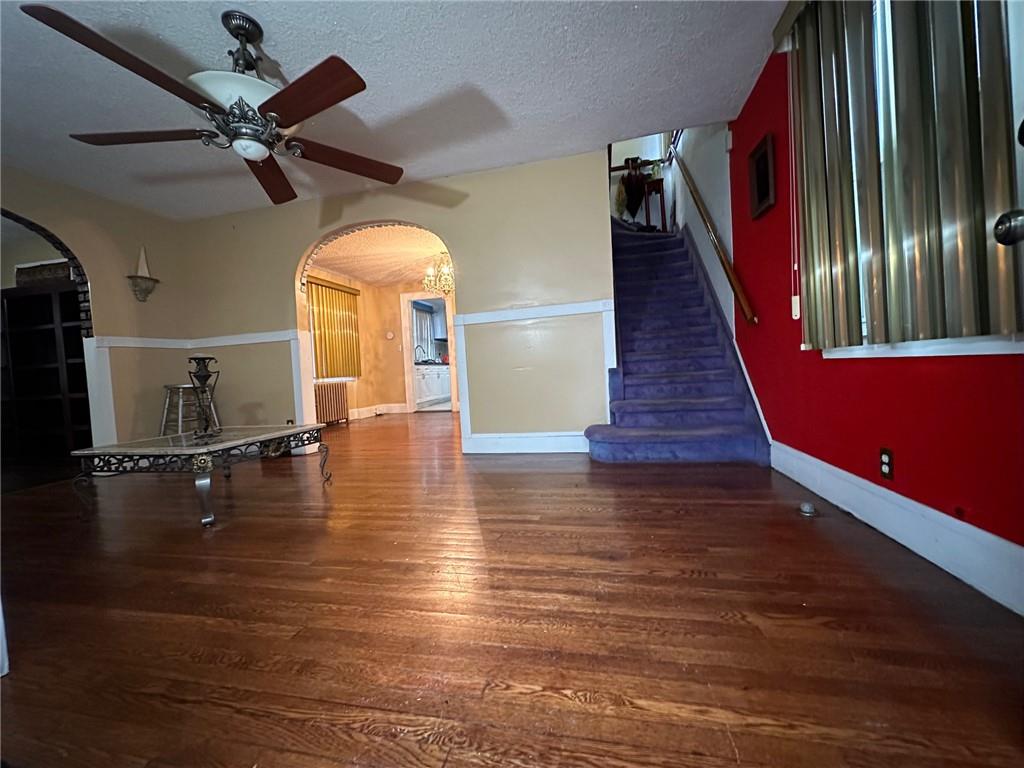 143-20 182nd Place Queens, NY 11413 - Photo 5 of 17 a view of a livingroom with wooden floor a ceiling fan and staircase