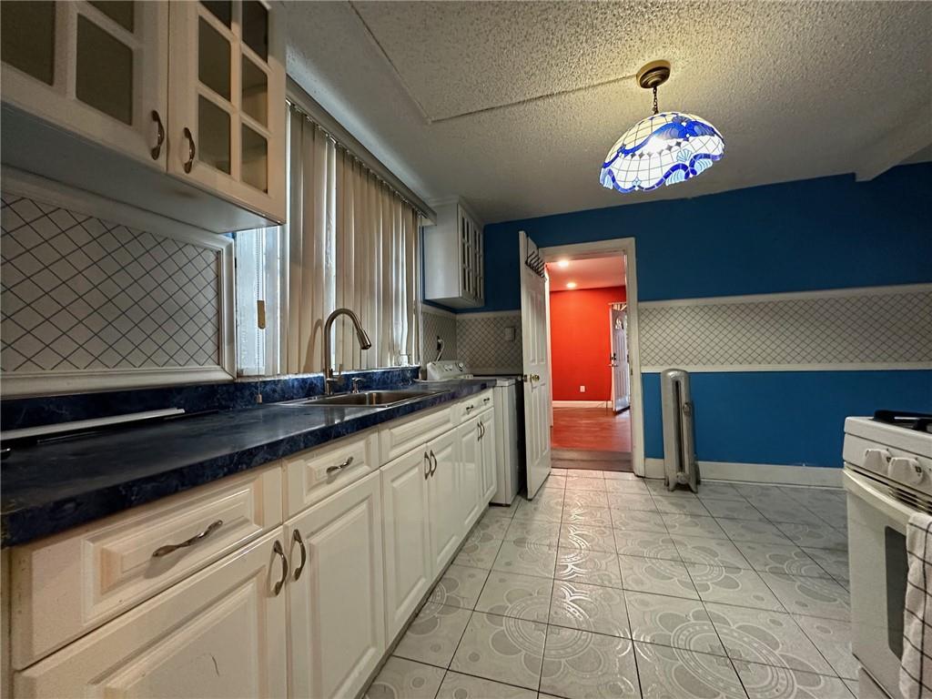 143-20 182nd Place Queens, NY 11413 - Photo 7 of 17 a view of a kitchen with a sink and chandelier