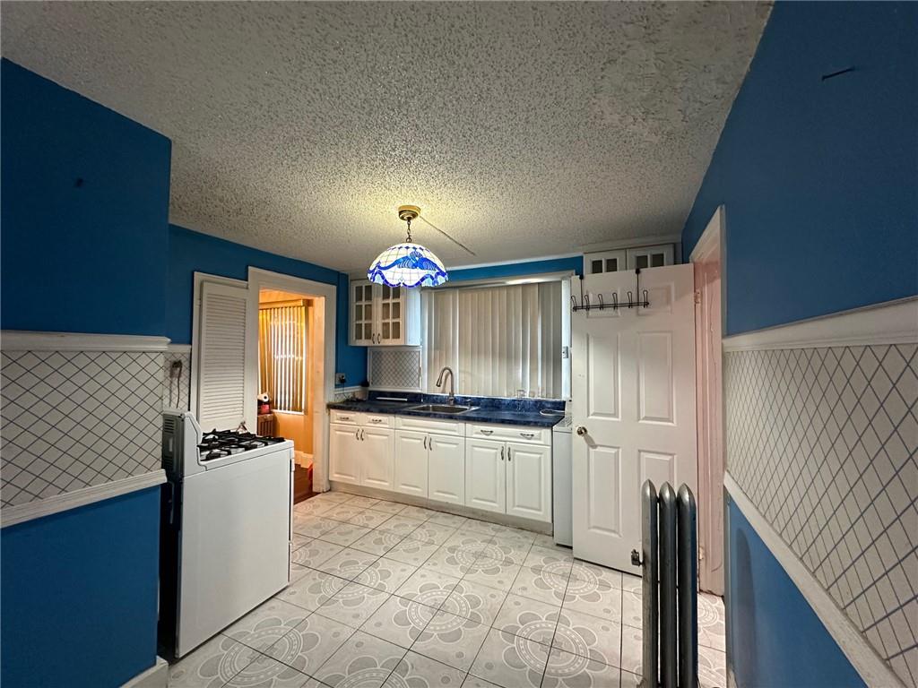 143-20 182nd Place Queens, NY 11413 - Photo 8 of 17 a kitchen with granite countertop a sink stove and refrigerator