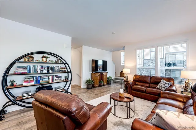 a living room with furniture a couch and a flat screen tv with wooden floor