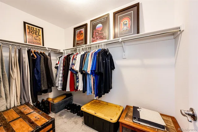 a view of walk in closet with clothes